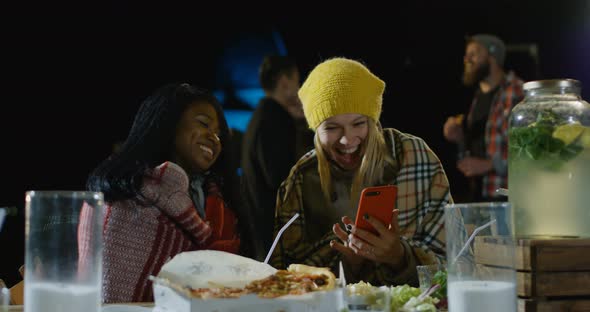 Female Best Friends Looking at Their Smartphone