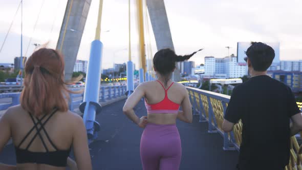 Young Man and Woman Friends Running at Bridge