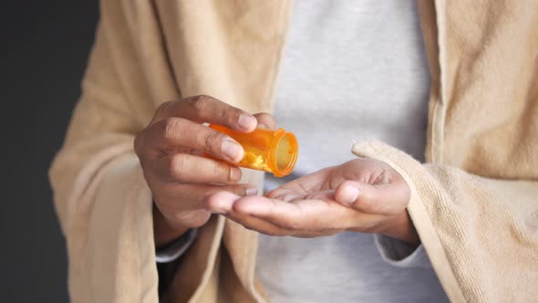 Man's Hand with Medicine Spilled Out of the Pill Container