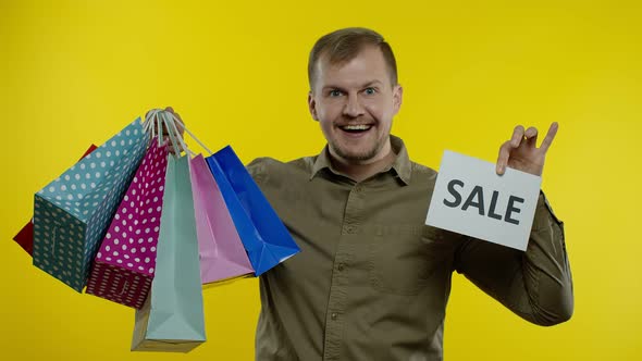 Happy Man Showing Sale Word Inscription, Smiling, Looking Satisfied with Low Prices, Slow Motion