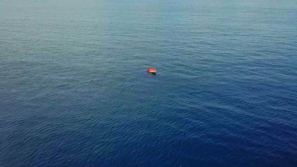 Tilt down aerial view of a fisherman on his boat off the coast of Westpunt, Curacao, Dutch Caribbean