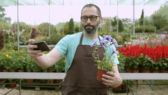 Happy Male Florist Holding Potted Flower and Taking Selfie