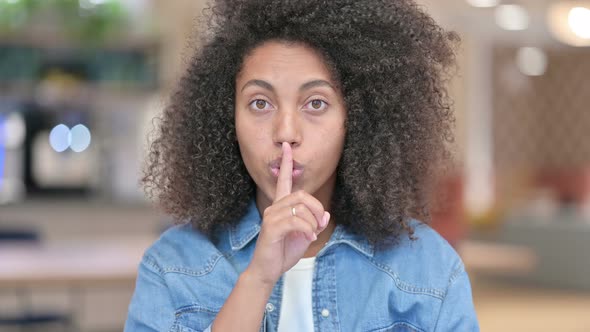 African Woman Putting Finger on Lips, Quiet Sign 