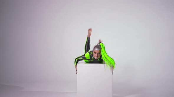 Front View Confident Flexible Woman with Futuristic Makeup in Costume Looking at Camera Doing