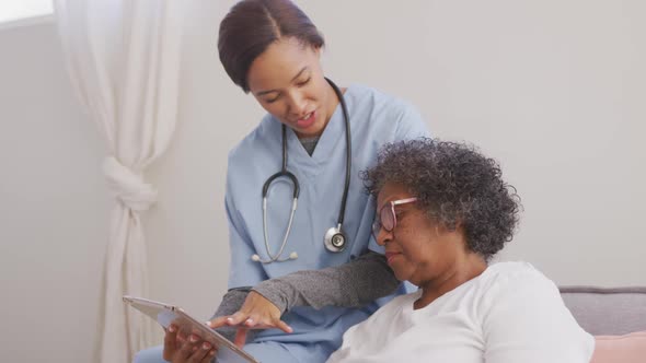 Mixed race woman being visited at home by a nurse. Social distancing and self isolation in quarantin