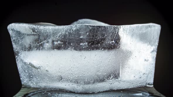 Ice Melts and Rotates on a Black Background