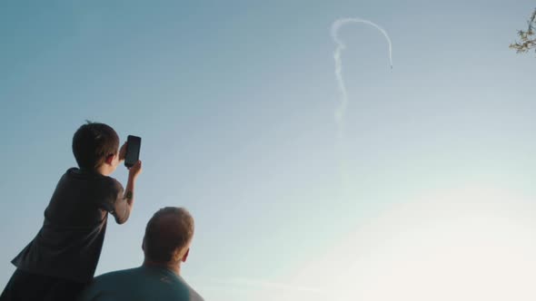 Dad And Kid Watching Stunt Plane At Air Show