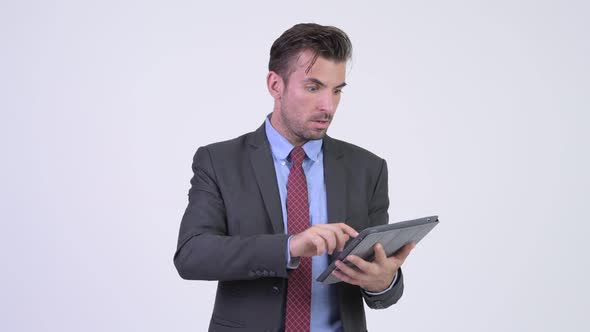 Young Stressed Hispanic Businessman Using Digital Tablet and Getting Bad News