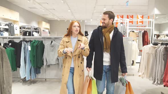 Young Happy Couple Carries Bags with Purchases.