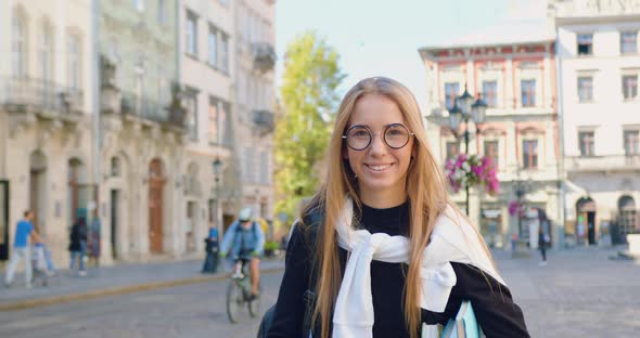 Girl in Casual Clothes Walking in the City Center with Ancient Buildings while Going to the Work
