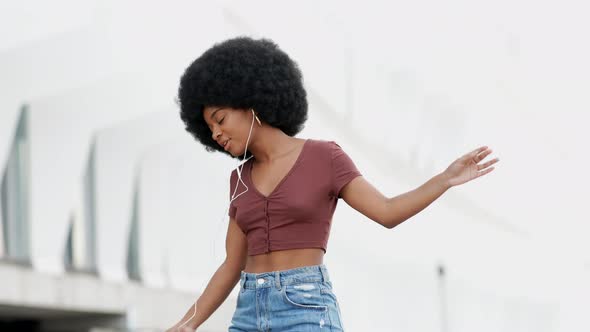Young woman dancing to music from smartphone