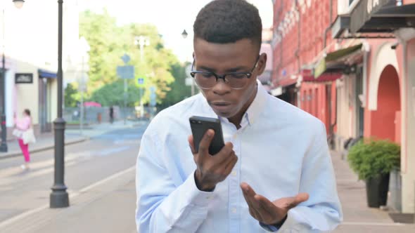 African Man Getting Angry on Call While Walking on the Street