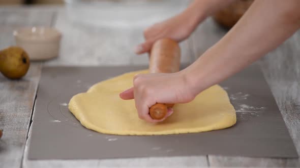 Woman Rolls Out Dough with Rolling Pin Close Up