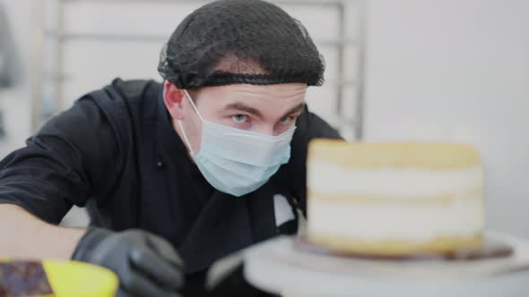 Closeup Portrait of Concentrated Cook Examining Layer Cake on Rotating Table