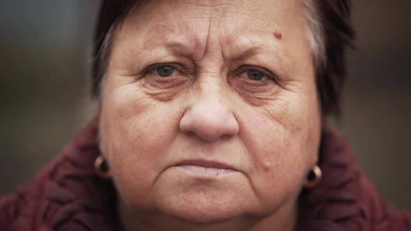 Portrait of Mature Woman Posing at Camera in Park