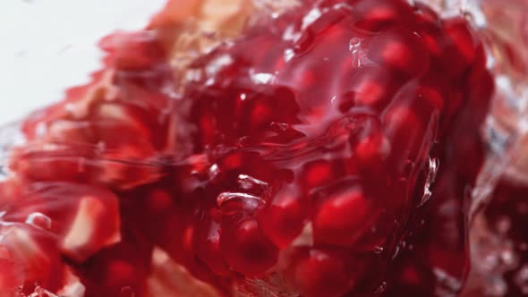 Water splash on open pomegranate. Slow Motion.