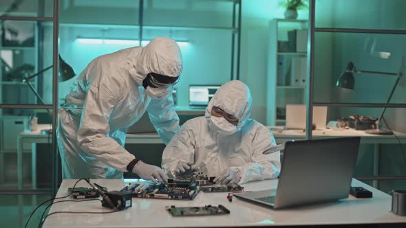 Engineers in Coveralls Developing Computer Hardware in Lab