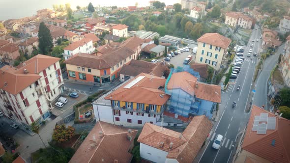 FPV drone shot over an Italian city near the coast, flying over houses, streets, around bell tower a