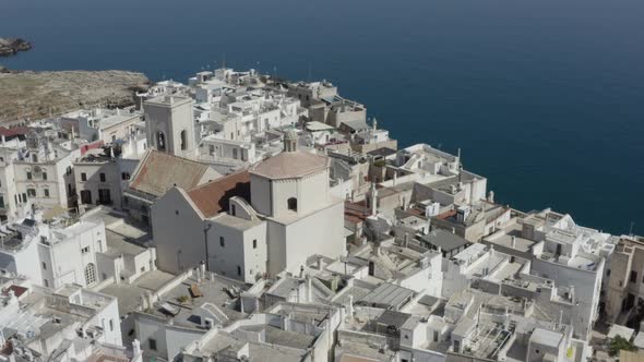 Aerial view with ascending orbit of Polignano a Mare in its characteristic white color. Italy