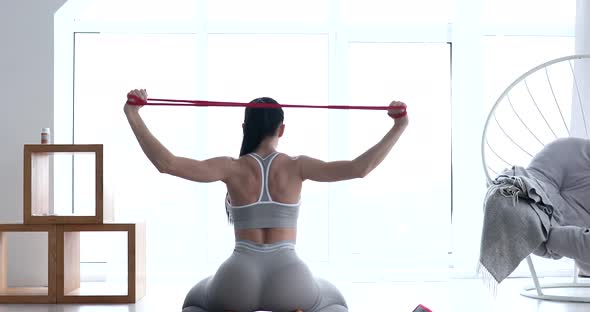 Woman doing exercises with resistance bands at home.