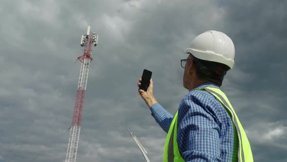 Telecommunications Engineer Checking the Signal From a Telecommunications Tower