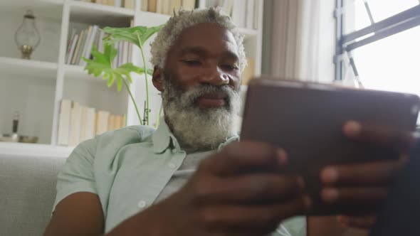 Video of african american senior man using tablet