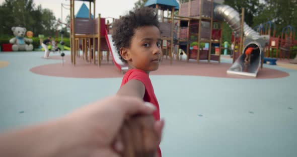 Follow Me Shot of Cute African Boy Lead Parent on Playground