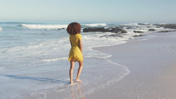 African American woman walking seaside