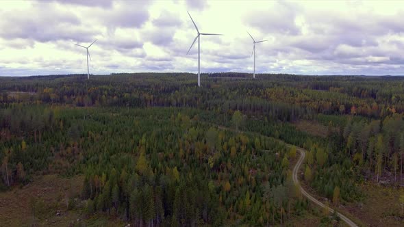 Aerial footage of three wind turbines in the Finnish forest.