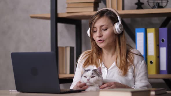 Female Employee in Headphones Relaxing During Work
