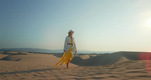 Romantic Woman Walking Alone in Desert at Sunset Hour