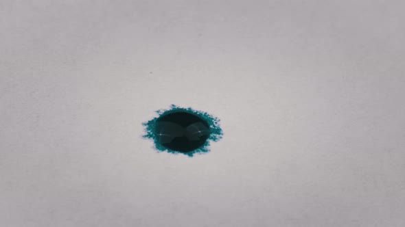 Drop of Blue Ink Falls on White Paper in Macro