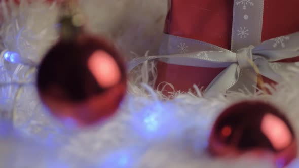 Christmas gift with red baubles lights and ribbon background