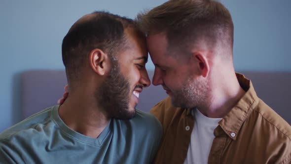 Multi ethnic gay male couple embracing and smiling