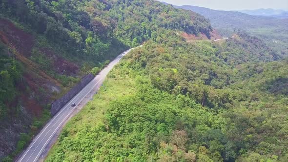 Drone Flies Over Modern Mountain Road with Car Among Jungle