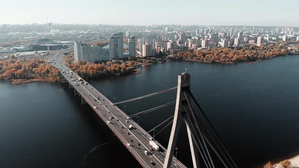 Heavy Traffic on Concrete Bridge Over the Industrial City River and High Buildings Area in Kiev