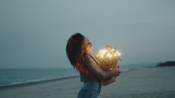 Happy Young Girl Enjoys Life on the Beach with Colorful Lights on Bag