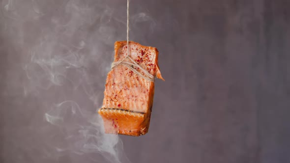 Piece of Smoked Trout with Spices Hangs on Rope at Steam