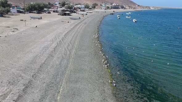 Drone video flying over a pebble beach on an island at Magdelena Bay Mexico while whale watching