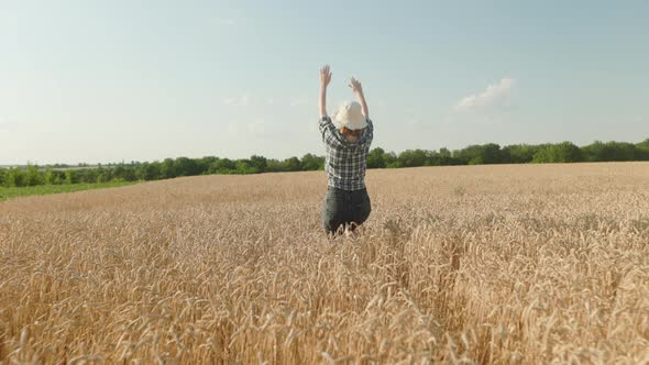 Woman runing fun across the wheat field. agriculture dream concept. girl farmer hands to sides runs