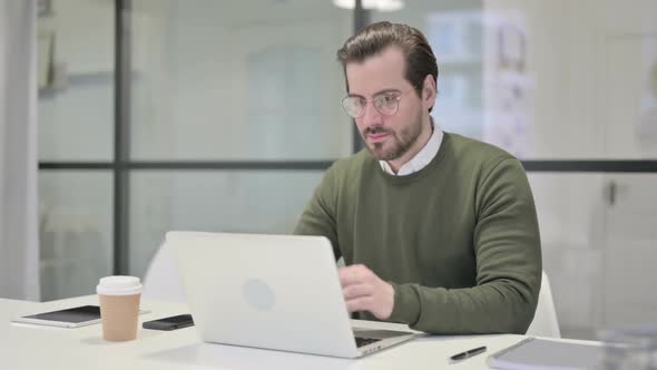 Young Businessman Working on Laptop in Office