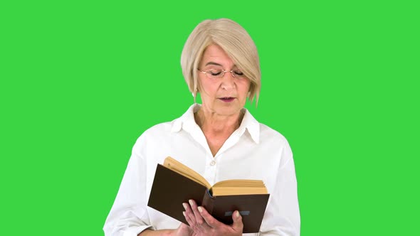 Beautiful Senior Woman Reading Aloud From a Book on a Green Screen Chroma Key