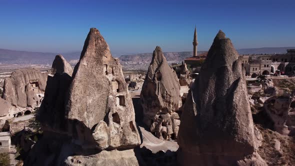 Group of Cone Shaped Tuff Cliffs with Uchisar Town on the Background Filmed By Drone