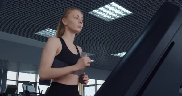 The Girl Goes In For Sports In The Gym. Running On A Treadmill 