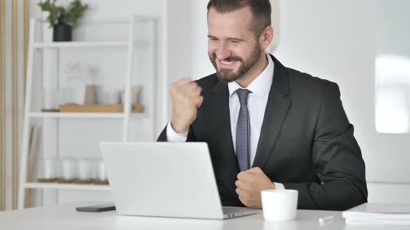 Businessman Celebrating Success, Working on Laptop