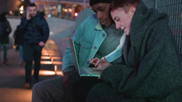 Young couple using laptop in the city