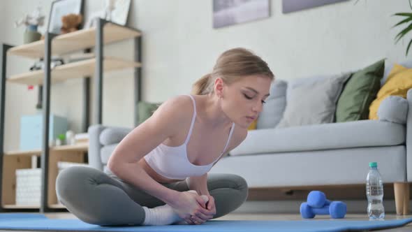 Young Woman Doing Stretches on Yoga Mat at Home