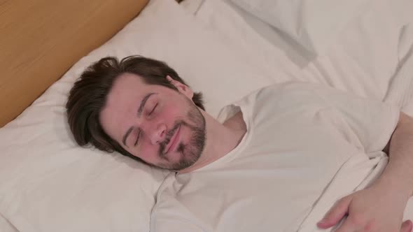 Casual Young Man Sleeping in Bed Peacefully