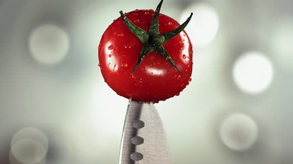 Fresh Tomato Falling Down on Knife Stuck