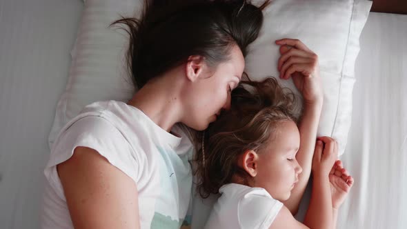 Young Mom Is Sleeping with Her Cute Little Daughter.